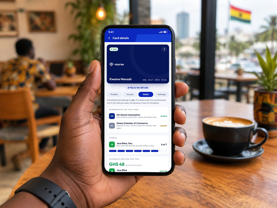 A hand holds a phone showing the Vaurse app: Kwame Mensah's blue Voscard on the Card details screen, with the Wallet tab open listing his memberships, coffee stamps and cashback.